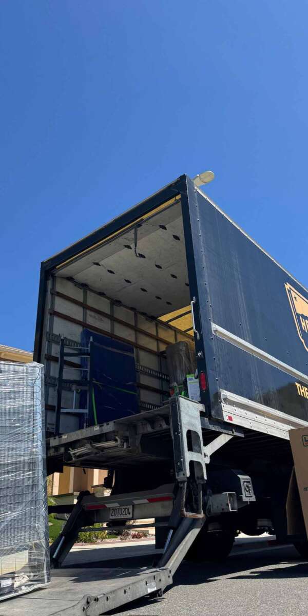 Hollywoodland Movers truck being loaded with wrapped shelving