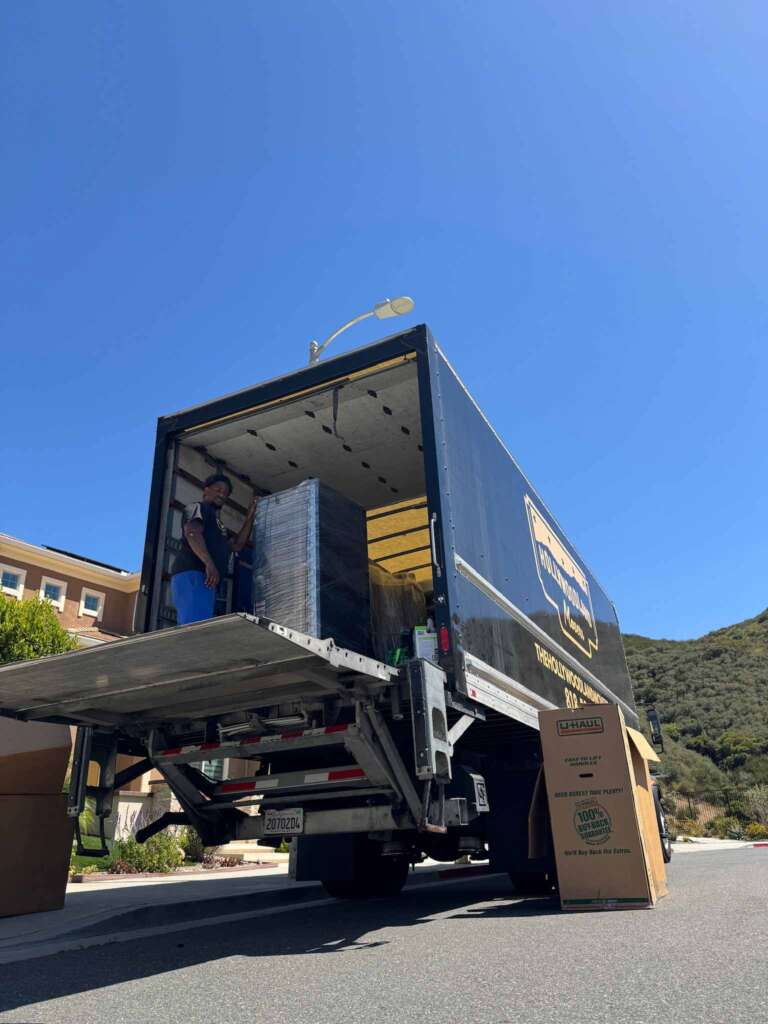 Hollywoodland Movers truck with liftgate down and boxes ready for loading