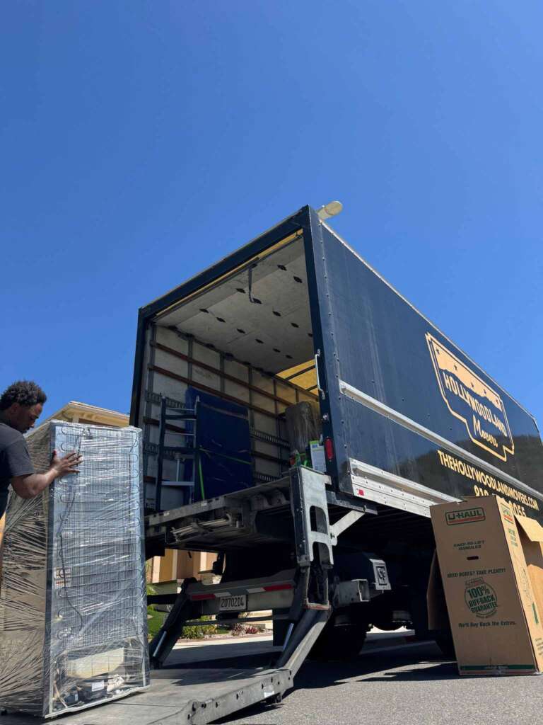 Mover loading wrapped furniture onto a Hollywoodland Movers truck